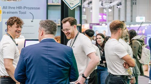 Besucher und Aussteller bei einem Gespräch an ihrem Stand