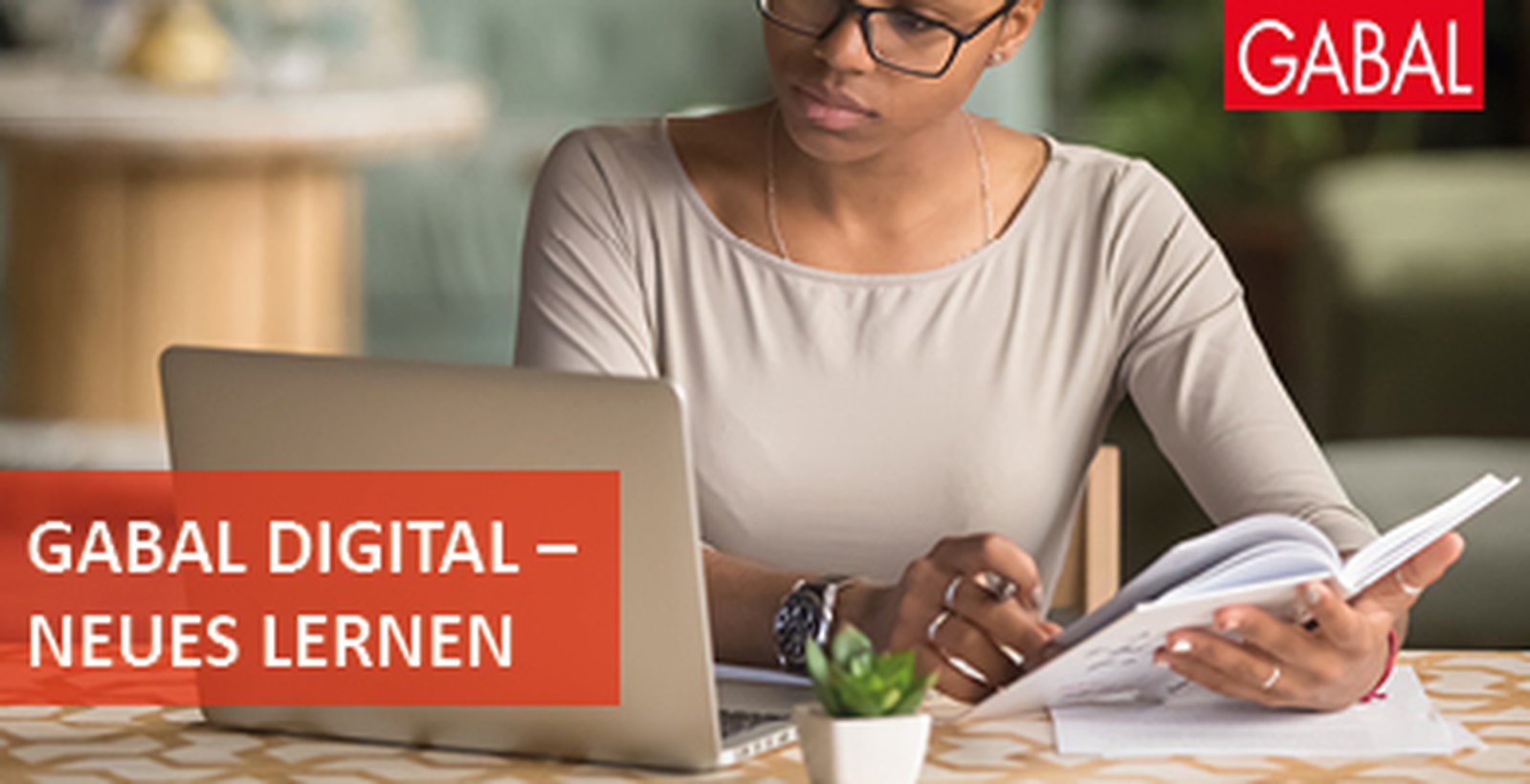 Eine Frau sitzt am Laptop und lernt, auf dem Bild befindet sich der Slogan "Lernen mit allen Sinnen!"